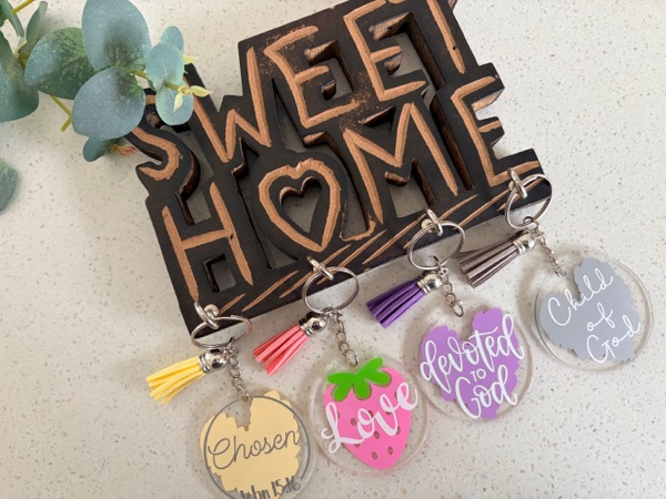 Acrylic keychains reading Chosen, Love, Devoted to God and Child of God, with yellow, pink, purple and grey tassels.